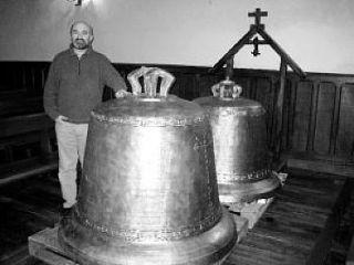 El párroco Fernando Razkin Tellería, junto a las dos campanas restauradas. N.G.