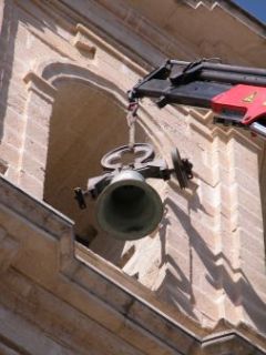 En la foto, el brazo de la grúa baja una campana desde la torre.