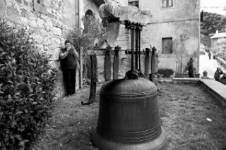 La campana, ya descendida, y, al fondo, el párroco Rafael Holubowicz la retrata con su cámara. 
