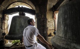 De espaldas, Félix Martínez Mazkiaran mueve los badajos de las dos campanas de mayor volumen durante el último repique de campanas - Autor: CARMONA, Luis / DIARIO DE NAVARRA