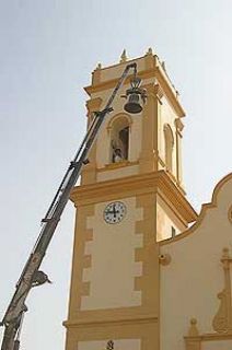 La grÚa baja una campana de la antigua iglesia de Guadasséquies.